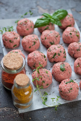 Raw meatballs on a baking paper ready to be cooked, close-up, selective focus