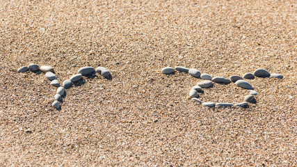 Aries and Taurus are made of stones on a sandy seashore. Signs of the zodiac of travelers and tourists.