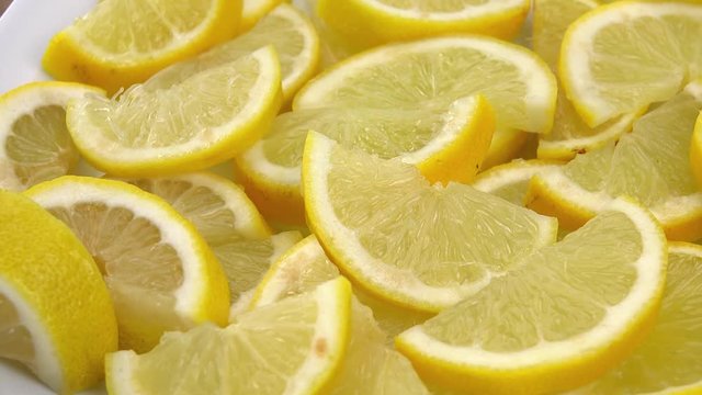 Portion of Lemon slices rotating on a wooden plate (not loopale; 4K)