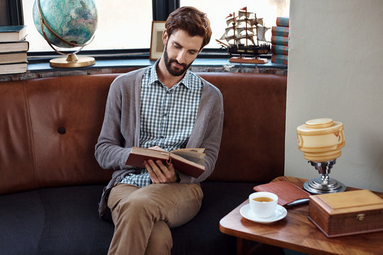 Casual man relaxes reads book in cafe restaurant