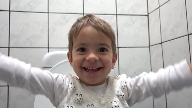 Happy faces of a child in toilet