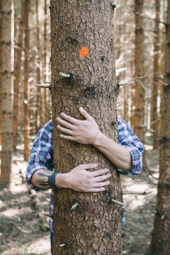 Young man hugging a tree