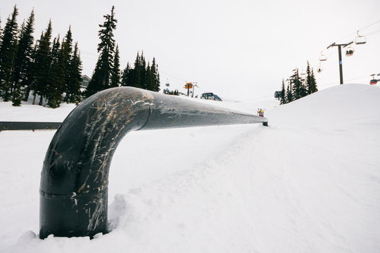 Rail on a snowpark and skier on the background