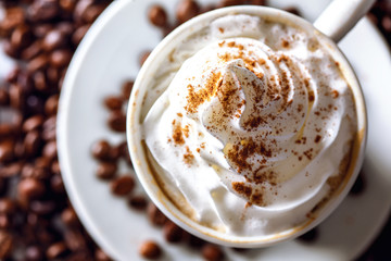 Close up of an irish coffee in a cup with coffee beans around