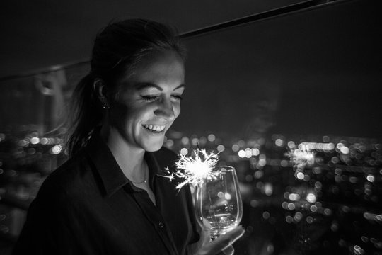 Festive time - black and white photo of a woman holding an sparkler in her hands