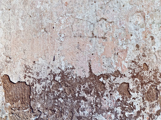 Damage, potholes and cracks on the cement covering of the old wall