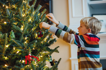 child decorating a Christmas tree