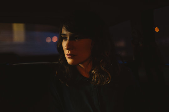 Portrait of beautiful woman at back seat of a car