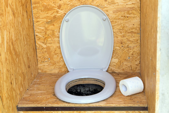 Plumpsklo / Plumpsklo mit Toilettensitz und Toilettenpapier