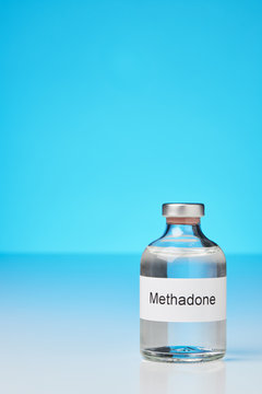 (English label in transverse format) A ampoule of methadone stands on white surface against gray background on the right.  with plenty of space for text