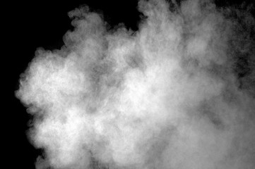 Freeze motion of white dust explosion on black background. Stopping the movement of white powder on dark background. Explosive powder white on black background.