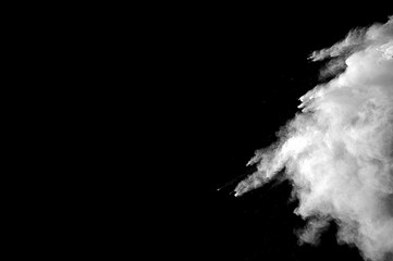 Freeze motion of white dust explosion on black background. Stopping the movement of white powder on...