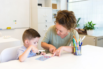 teacher woman learn to write character preschooler child boy, while sitting in the classroom