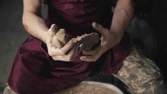 Hands of the master potter and vase of clay on the potter's wheel close-up. Master crock man. Twisted potter's wheel.