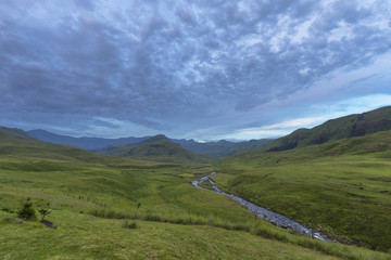 Clouds after sunset over green valley