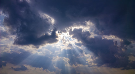 Fototapeta na wymiar Gods light. Rays of light through dark clouds. sun shines from cloud
