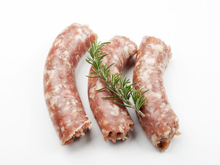 From above uncooked sausage with rosemary on white background. Isolated.