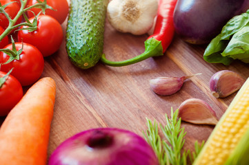 The set of colorful vegetables and spices on wooden table, copy space image - Onion, corn, tomatoes, garlic, carrots, cucumber, pepper, eggplant, basil, rosemary