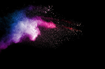 Abstract art colored powder on black background. Frozen abstract movement of dust explosion...