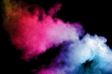 Naklejka na ściany i meble Abstract art colored powder on black background. Frozen abstract movement of dust explosion multiple colors on black background. Stop the movement of multicolored powder on dark background.
