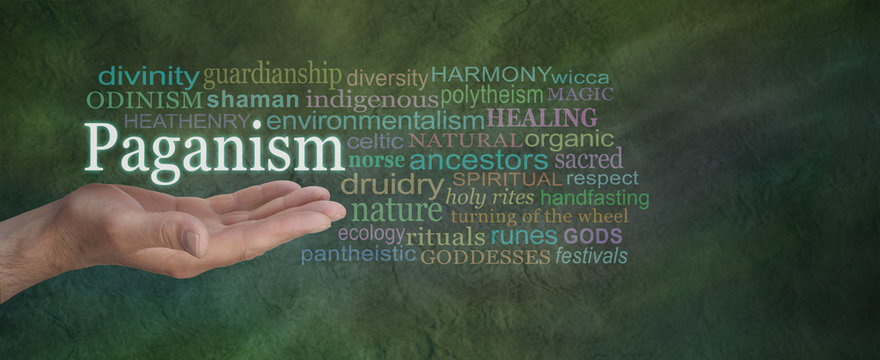 Male hand outstretched on a green stone effect background with the word PAGANISM floating above surrounded by a relevant word cloud
