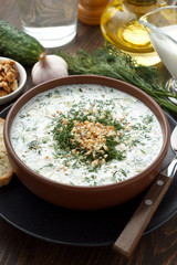 Traditional bulgarian tarator with yogurt, cucumber and other ingredients on wooden table. - 165845853