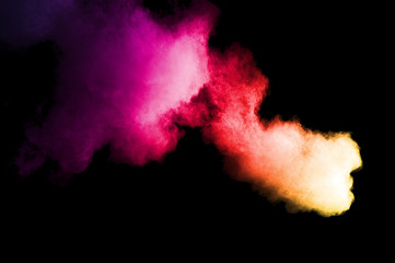 Fototapeta na wymiar Abstract art colored powder on black background. Frozen abstract movement of dust explosion multiple colors on black background. Stop the movement of multicolored powder on dark background.