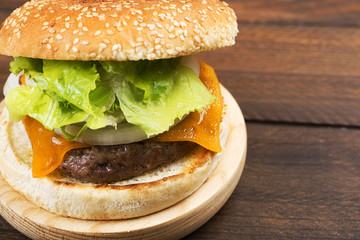 Close-up of appetizing burger on board. Copy space.