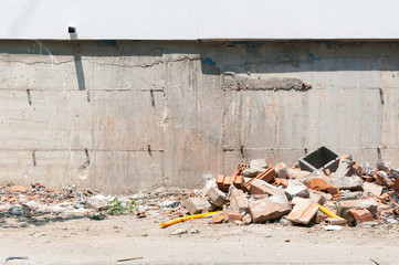 Construction site remains of building material on the ground by the foundation base.