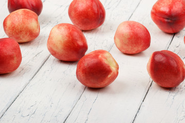 Ripe red peaches on the white wooden table