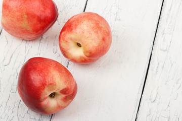Ripe red peaches on the white wooden table