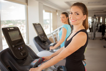 Fototapeta premium Young woman biking in the gym, exercising legs doing cardio workout