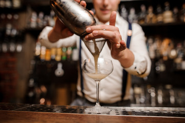 no face bartender pouring cocktail into glass