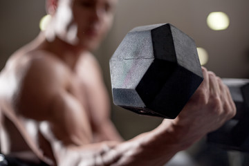 Fototapeta na wymiar Young adult bodybuilder lifting weight in gym.