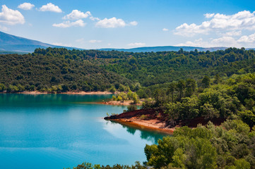 Lac de haute montagne avec plage et ciel bleu se reflétant dans une eau bleue turquoise en forme...
