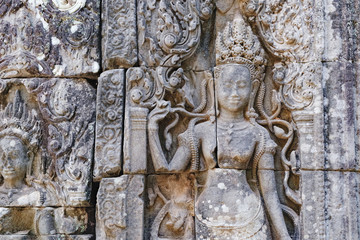 Beautiful Cambodian women dancing Apsaras. Old Khmer art carvings on the wall of Prasat Bayon, the central temple of Angkor Thom Complex, Siem Reap, Cambodia.