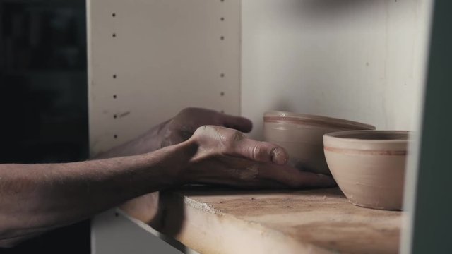 Hands of the master potter and vase of clay on the potter's wheel close-up. Master crock man. Twisted potter's wheel.