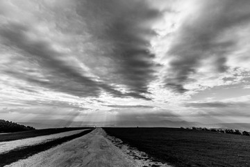 A view of a mountain road with a very low and menacing rooftop of clouds