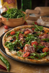 Traditional pizza with prosciutto and arugula