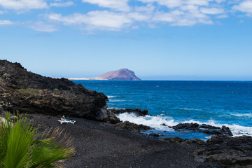 Fototapeta na wymiar Black sand volcanic beach with sunbeds in Tenerife, Canary islands, Spain