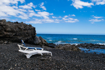 Black sand volcanic beach with sunbeds in Tenerife, Canary islands, Spain