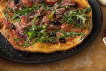 Traditional pizza with prosciutto and arugula