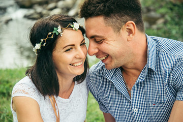 Fototapeta premium couple sits near mountain river