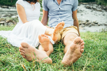 couple sits near mountain river