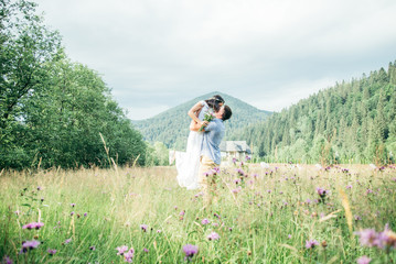 couple in love walking in feild with beautiful view on moutains