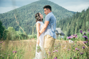 couple in love walking in feild with beautiful view on moutains