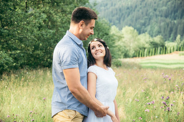 couple in love walking in feild with beautiful view on moutains