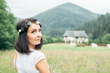 young pretty woman portrait with flowers in mountains