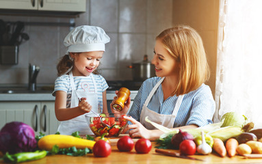 Healthy eating. family mother and child girl preparing vegetarian vegetable salad at home in kitchen