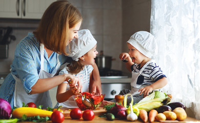Healthy eating. Happy family mother and children prepares  vegetable salad